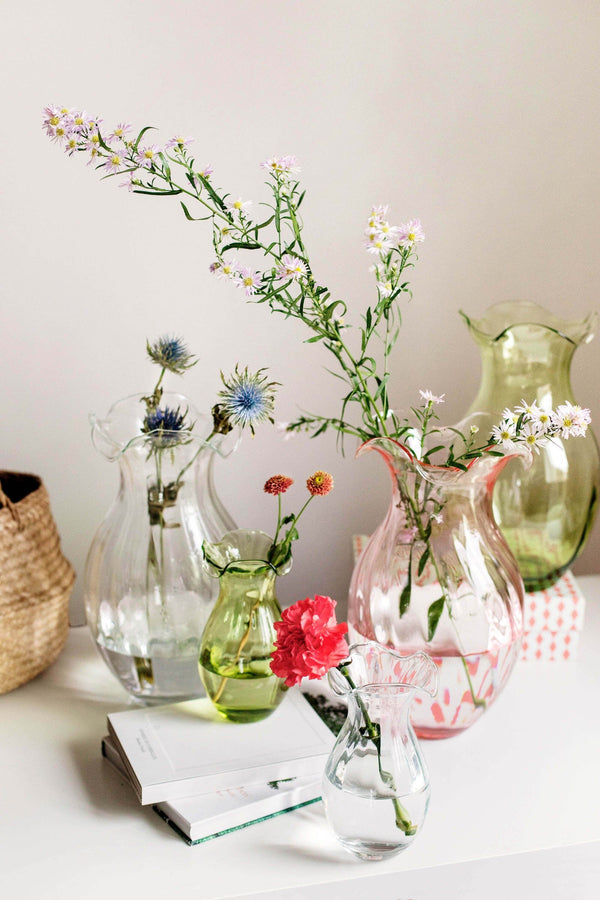 Hibiscus Glass Vertical Fluted Small Vase in clear, pink, and green with floral arrangements.