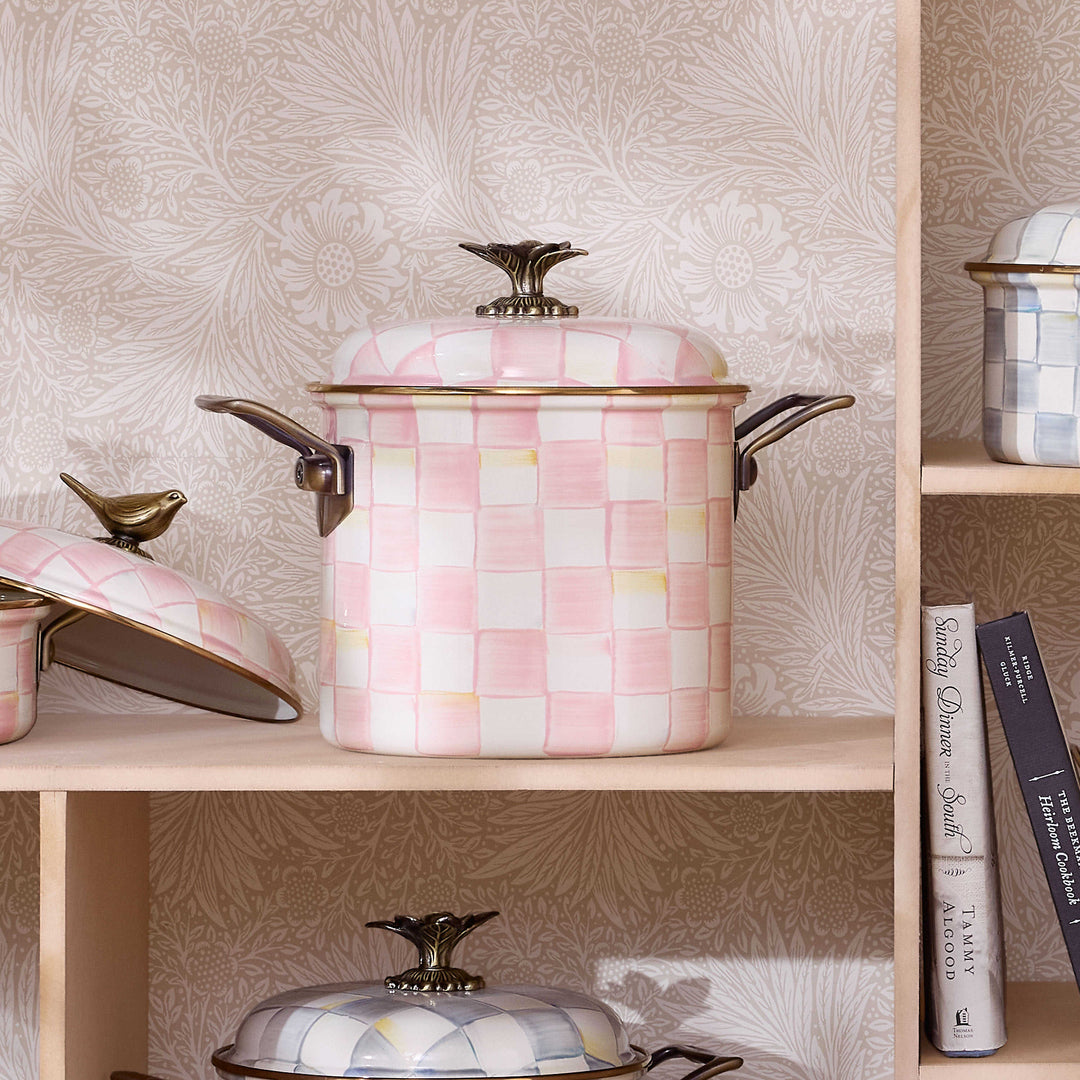 Rosy Check 7 Qt. Stockpot with hand-painted pink and white checks on a shelf with cookbooks.