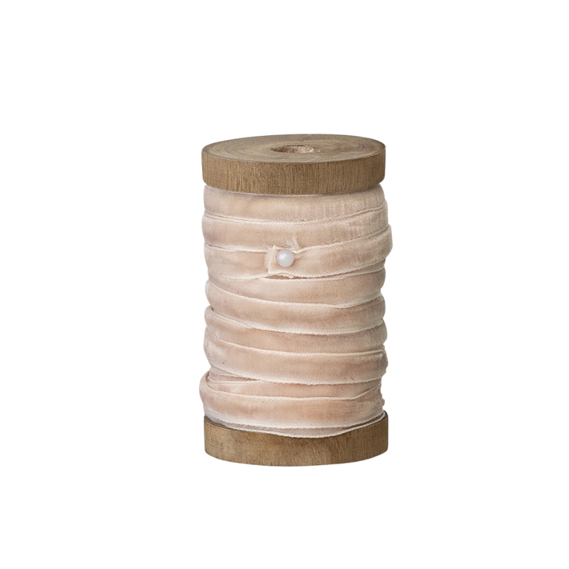 10 yards of 1/4 inch wide blush pink velvet ribbon wrapped around a rustic wooden spool.