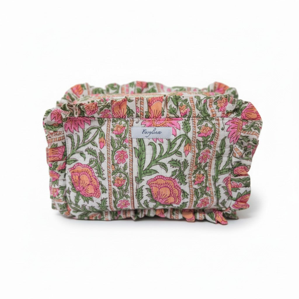 Frilly toiletry bag with a pink and orange floral block print pattern and ruffled edges.