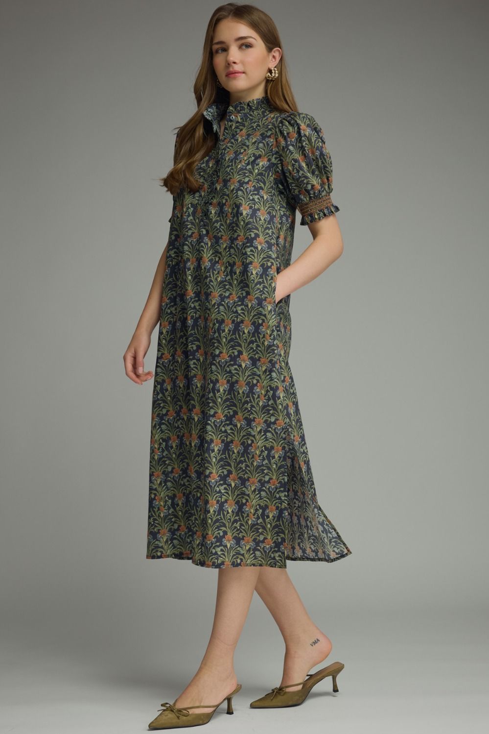 Woman wearing a Mary Floral Print Short Puff Sleeve Midi Dress with ruffled neck and side pockets.