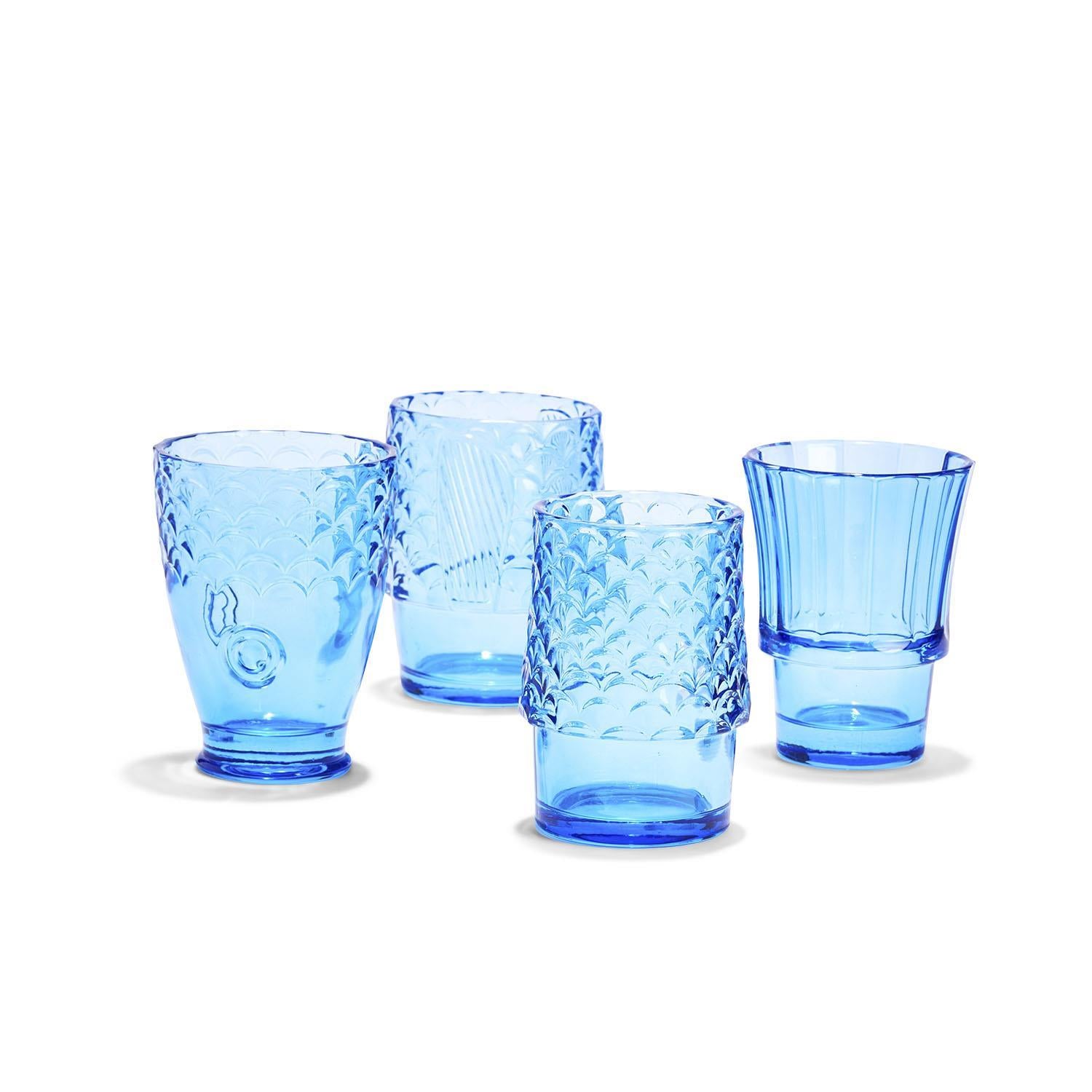 Set of four blue glass tumblers with embossed fish and scale patterns on a white background.