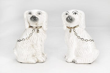Set of two Staffordshire terrier figurines in black glazed ceramic with white accents.