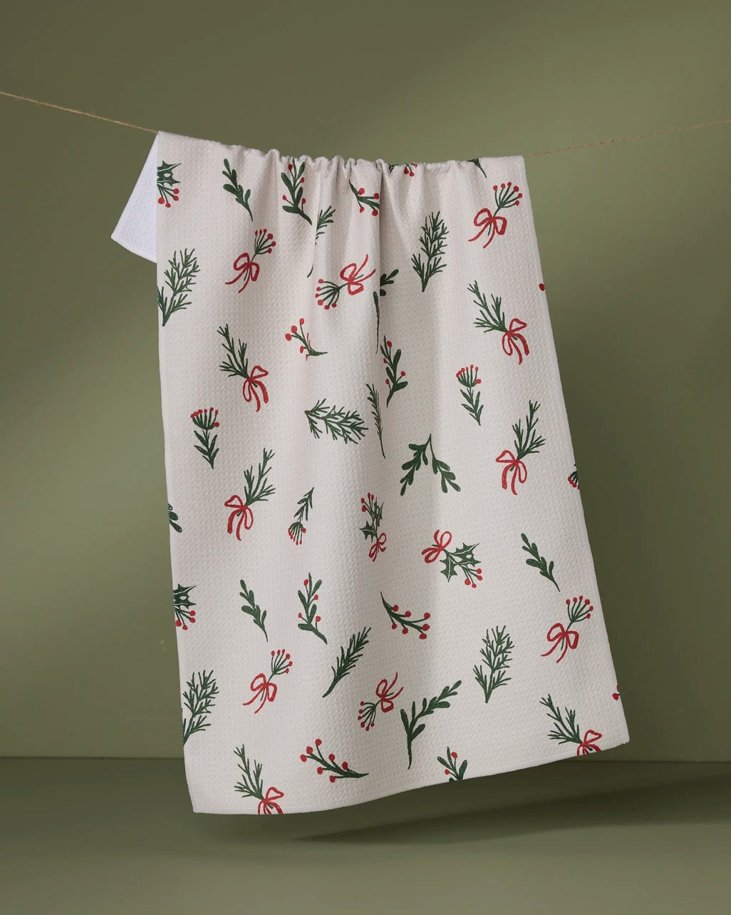 Holiday tea towel with festive red and green waffle weave print featuring a hanging loop.
