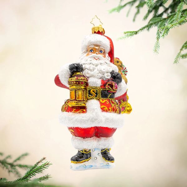 A Claus To Celebrate glass ornament featuring a Black Santa holding a lantern and a toy bag.
