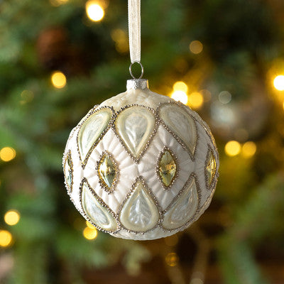 Golden Pearl Pattern Ball Ornament made of glass hanging from a tree with bokeh lights.