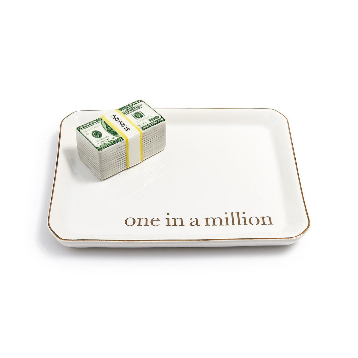 White ceramic trinket tray with gold trim and 'one in a million' text, holding a stack of play money.