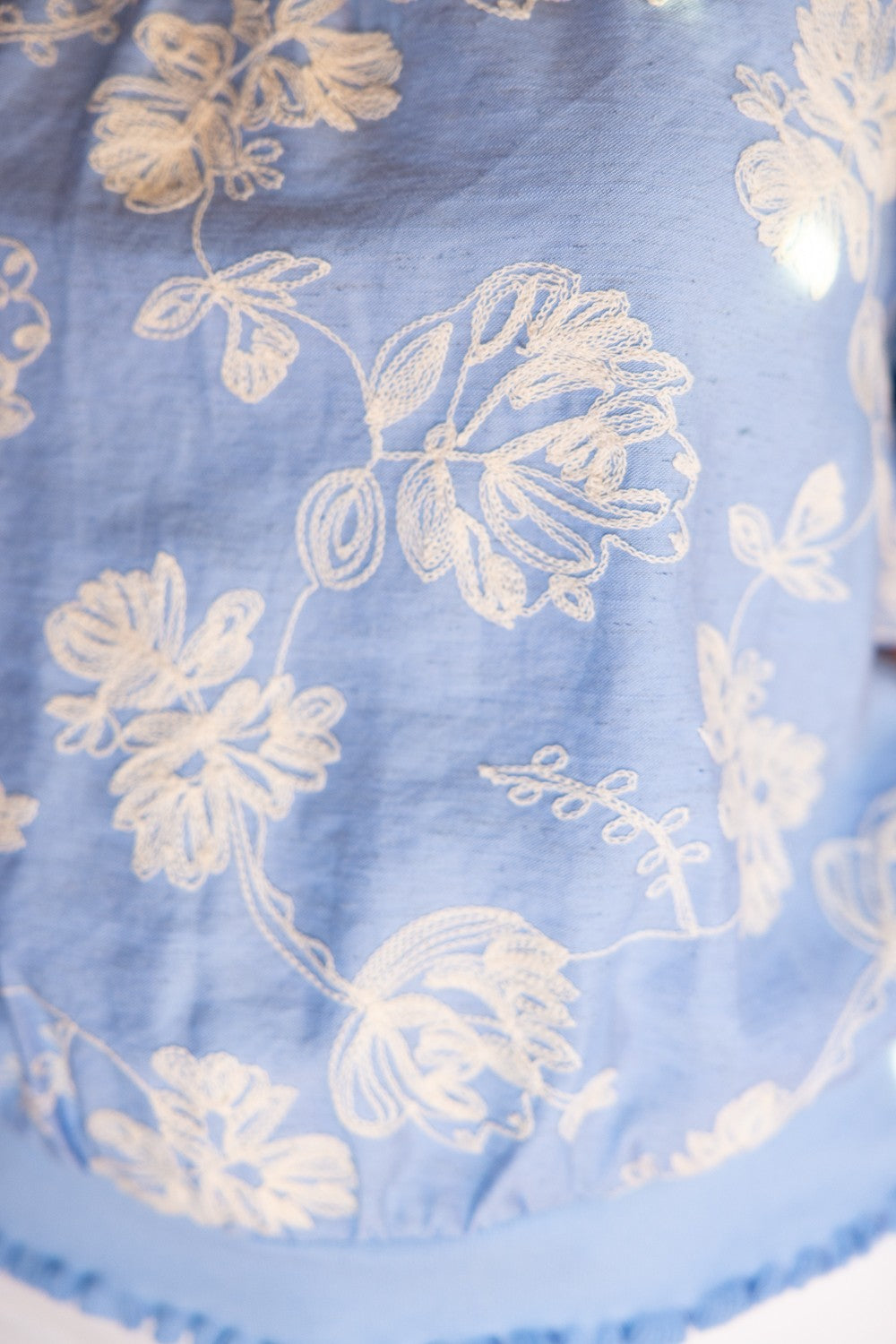 Scarlett floral embroidered top with bubble sleeves, ribbed bands at neck and hem in woven fabric.