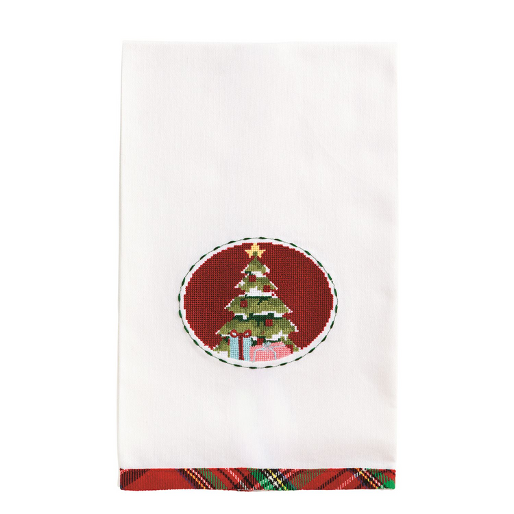 White cotton hand towel with a needlepoint Christmas tree in a red oval and a tartan plaid hem.