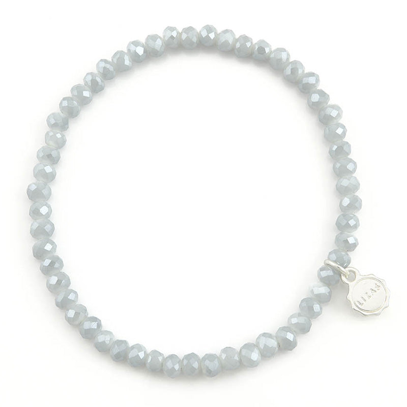 Lizas Quadro light grey faceted crystal stretch bracelet with a silver brand charm.