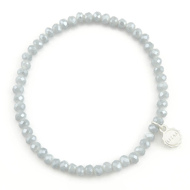 Lizas Quadro light grey faceted crystal stretch bracelet with a silver brand charm.