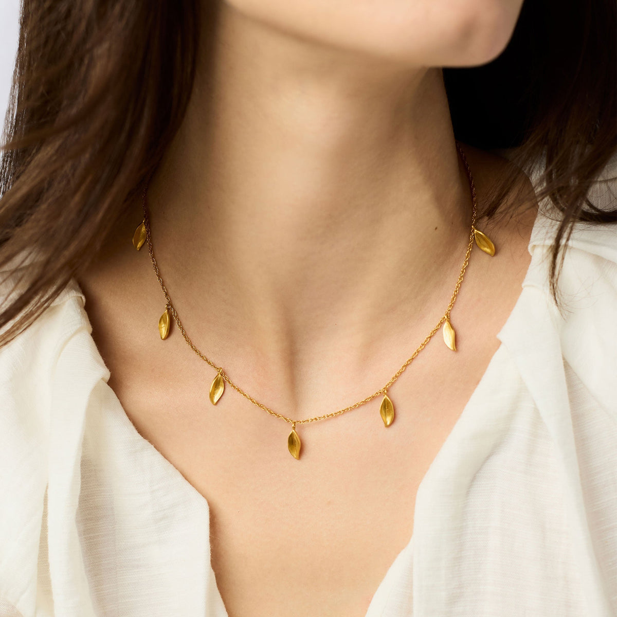 Willow delicate charm necklace with adjustable chain in silver tone featuring a small pendant.
