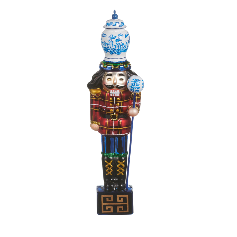 8-inch glass nutcracker ornament wearing a red plaid jacket and a blue and white porcelain hat.