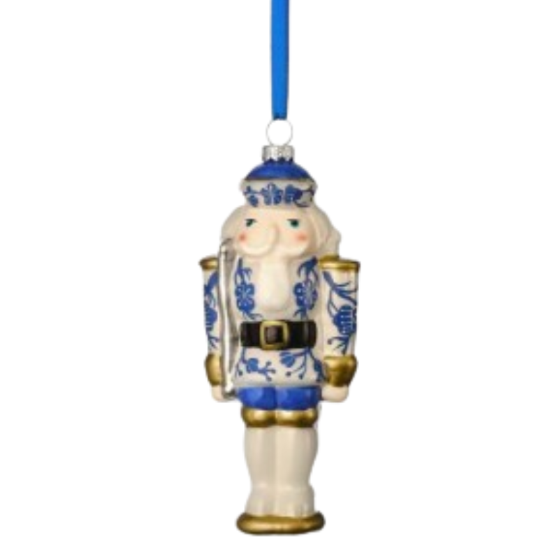 Glass toy soldier ornament with blue and white floral patterns and a blue hanging ribbon.