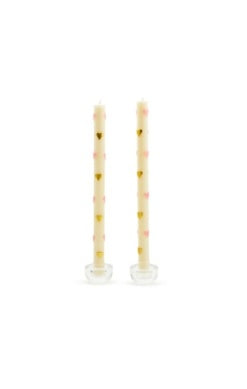 Set of two cream-colored taper dinner candles decorated with small pink and gold hearts.