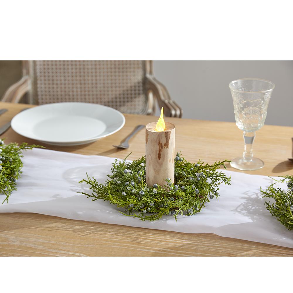 A 3-inch green plastic juniper candle ring with blue berries around a wooden pillar candle.