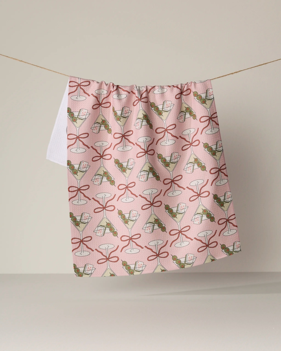 Everyday Tea Towel with a pink martini, olive, and playing card pattern hanging on a clothesline.