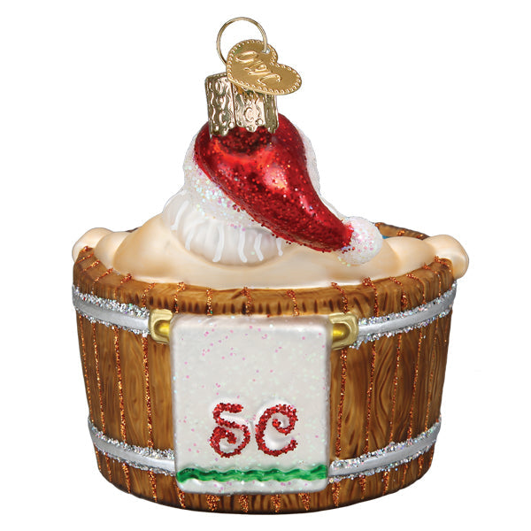 Santa Claus wearing a red hat relaxing in a wooden hot tub glass Christmas ornament.