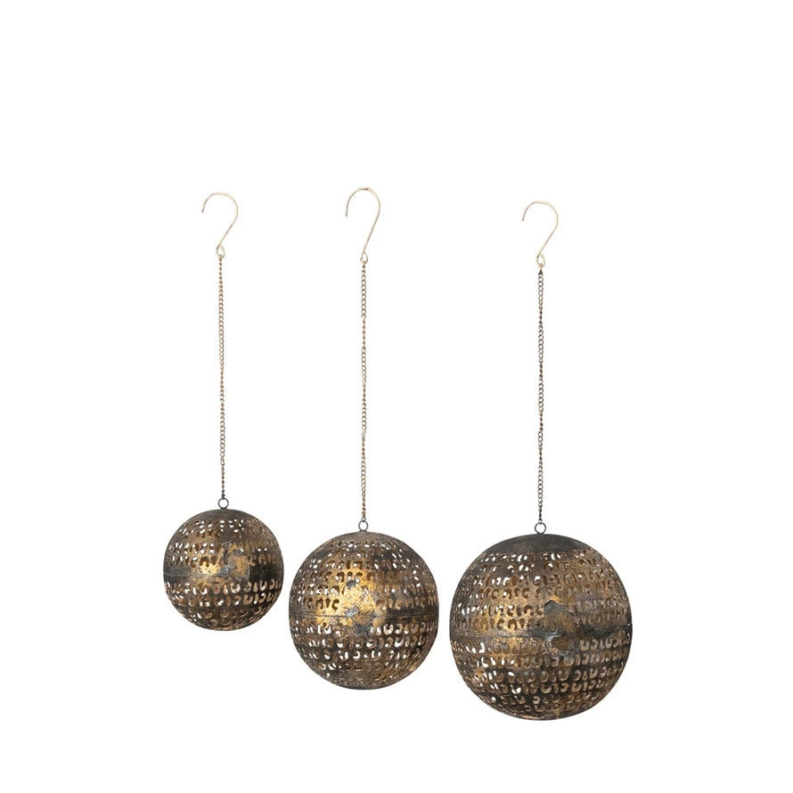 Set of three metal opening ball ornaments with cut-outs and hanging chains in varying sizes.