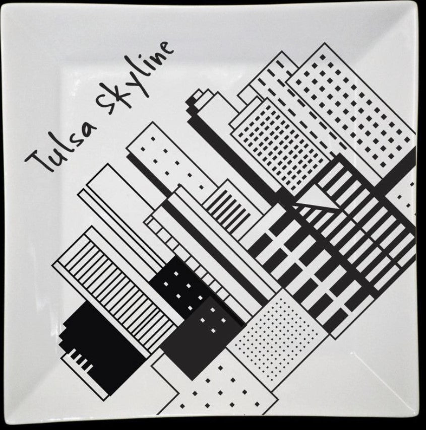 Square white plate featuring a black graphic illustration of the Tulsa skyline.