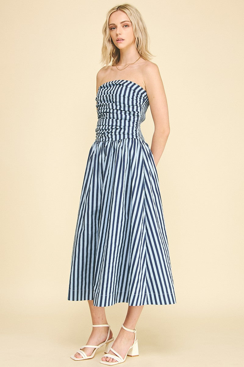 Woman wearing the Diana blue and white striped strapless tube maxi dress with a tucked bodice.