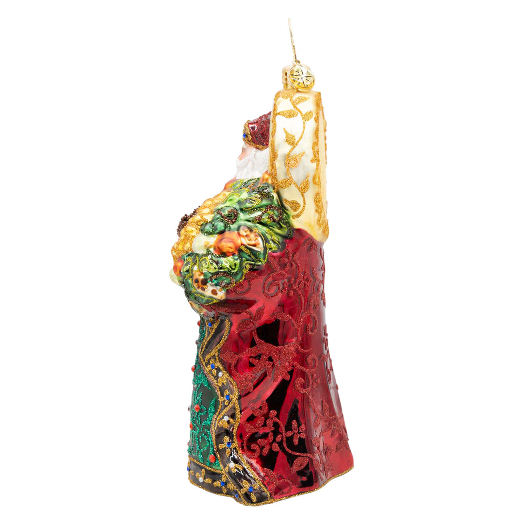 Regal Radiance Santa ornament in a red patterned robe holding a green and gold floral bouquet.