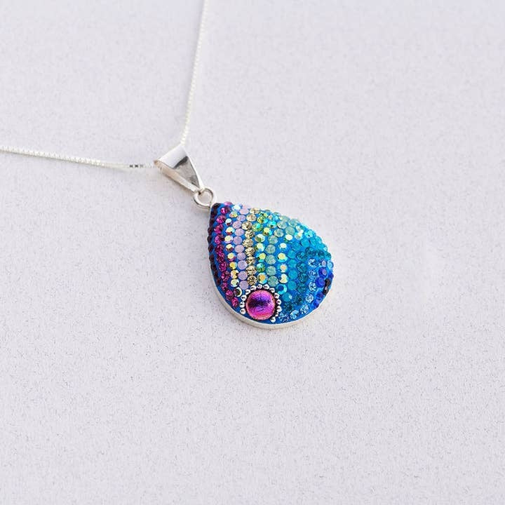Large oval sterling silver pendant with purple and blue Austrian crystals in a handcrafted pattern.