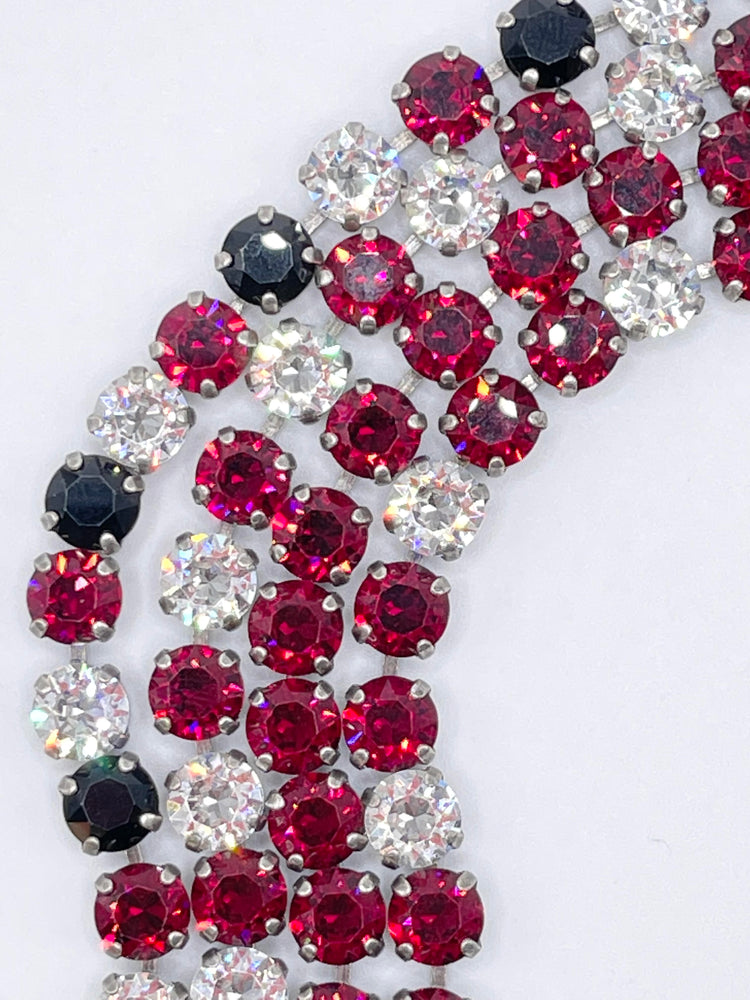 Close-up of the Rome Classic Bracelet featuring rows of deep red, black, and clear round stones.