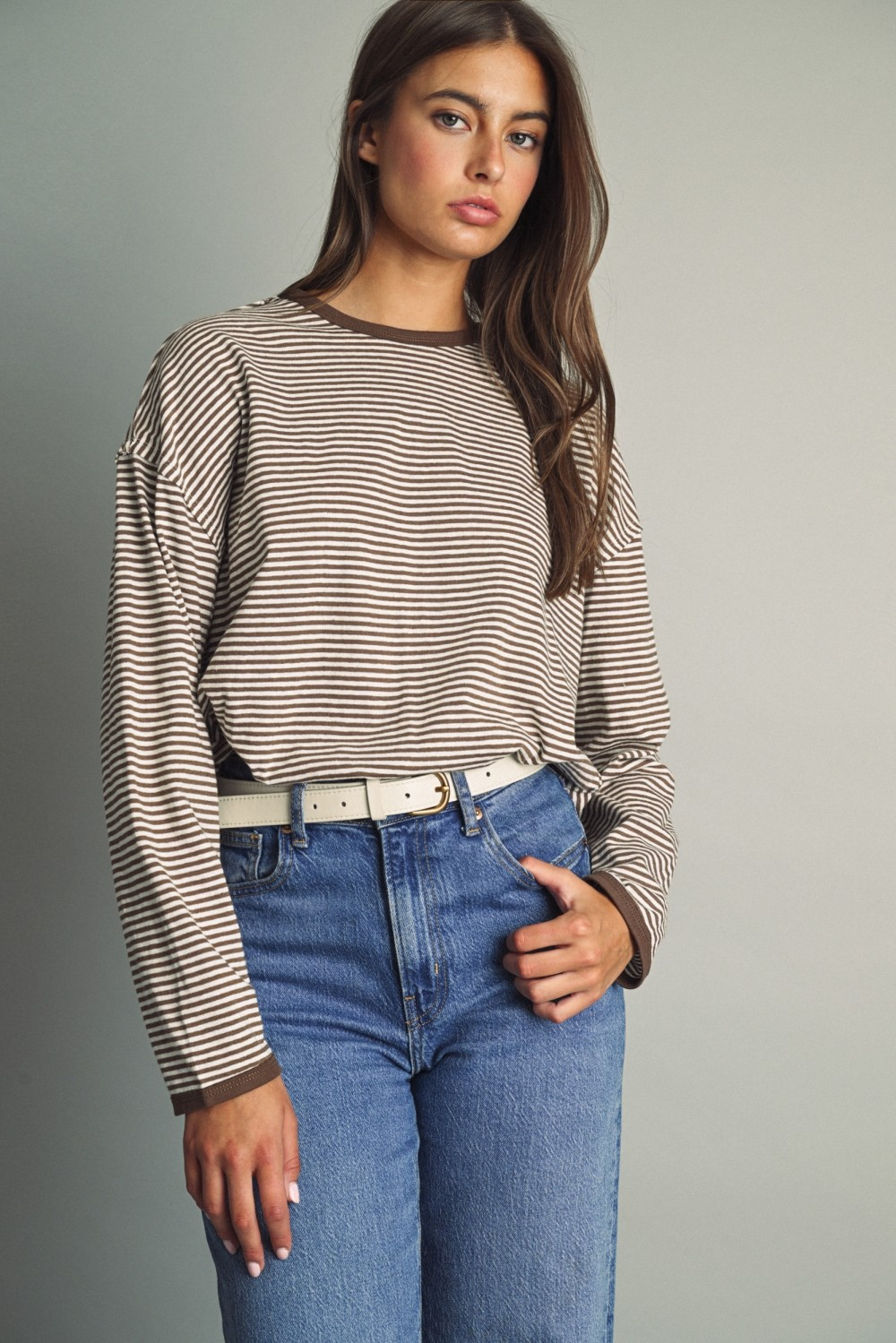 Woman wearing the Alice Thin Striped Long Sleeve Light Top in brown and white with blue jeans.
