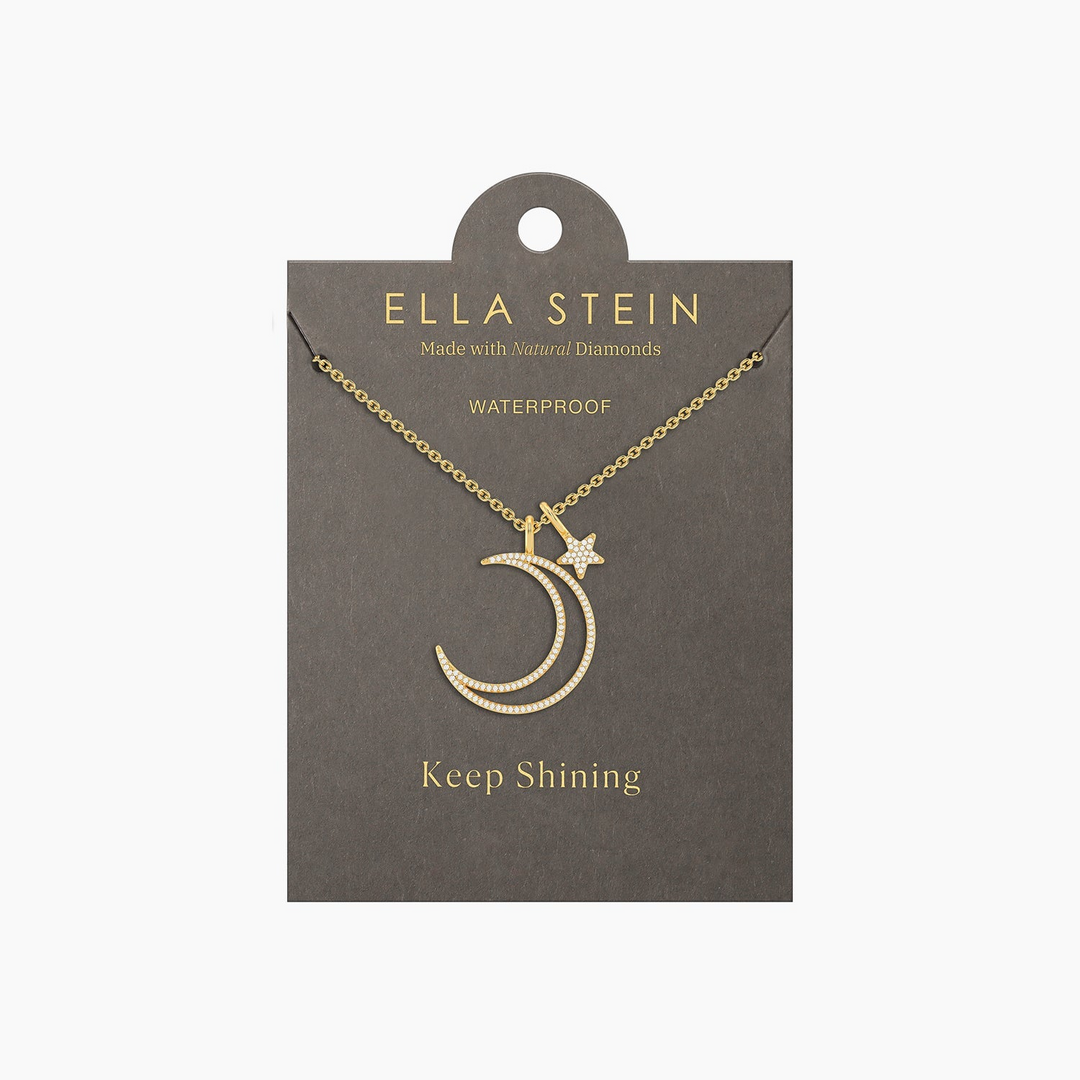 Gold crescent moon and star pendant necklace with natural diamonds on a grey display card.