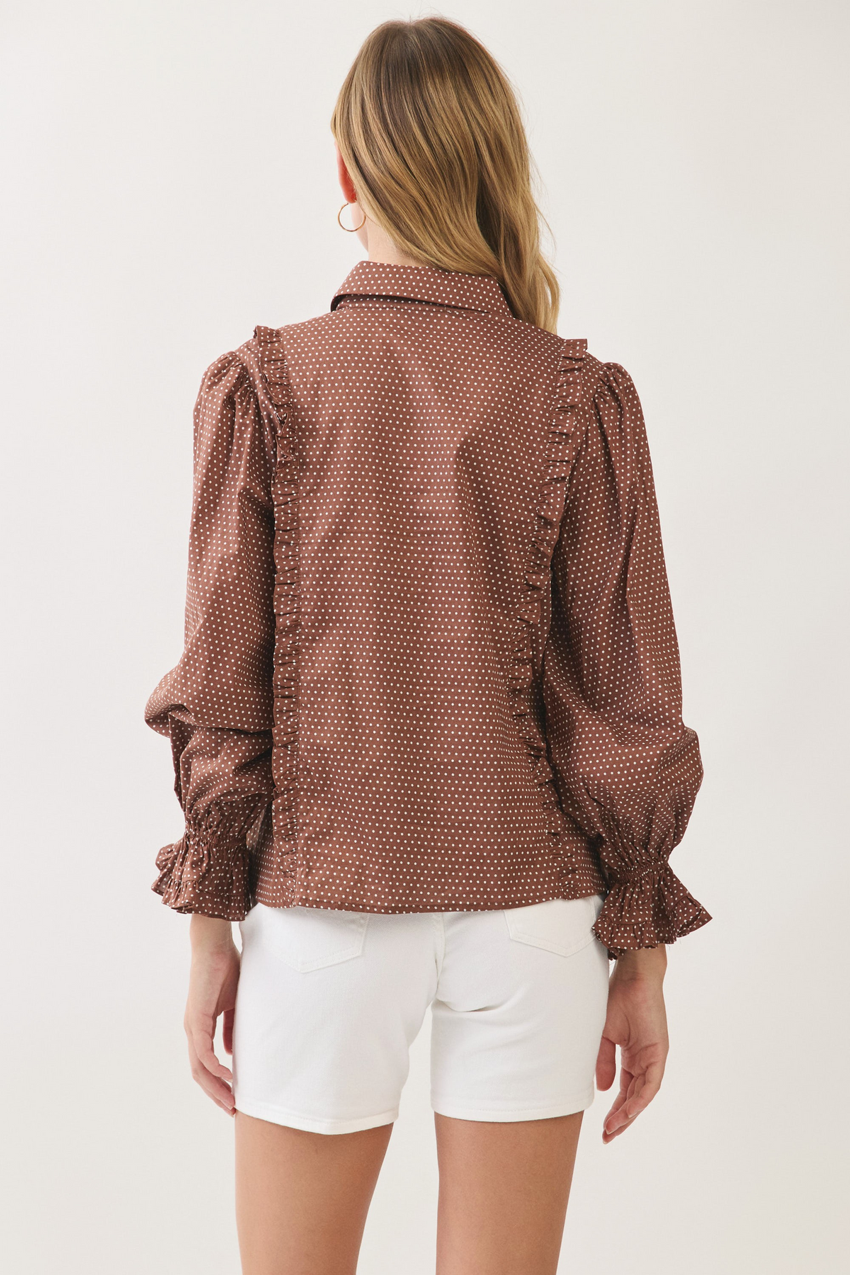 Back view of a woman wearing a brown Willa Polka Dot Button Down Shirt with ruffled details.