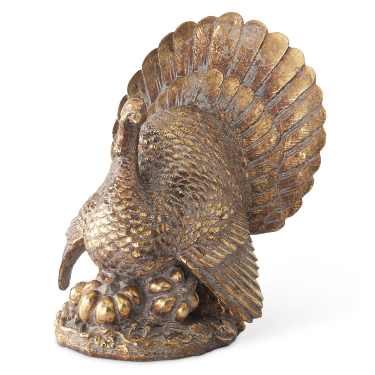 11.5 inch antique gold resin turkey figurine standing on pumpkins with a fanned tail.
