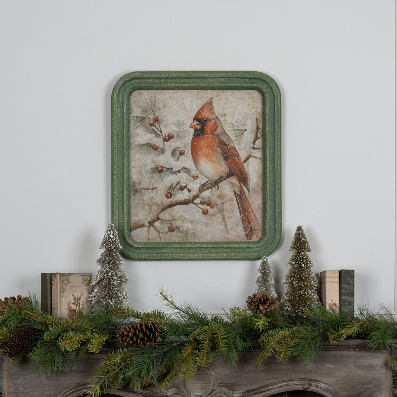 Framed winter scene print on glass showing a red cardinal perched on snow-covered branches against a blue sky.