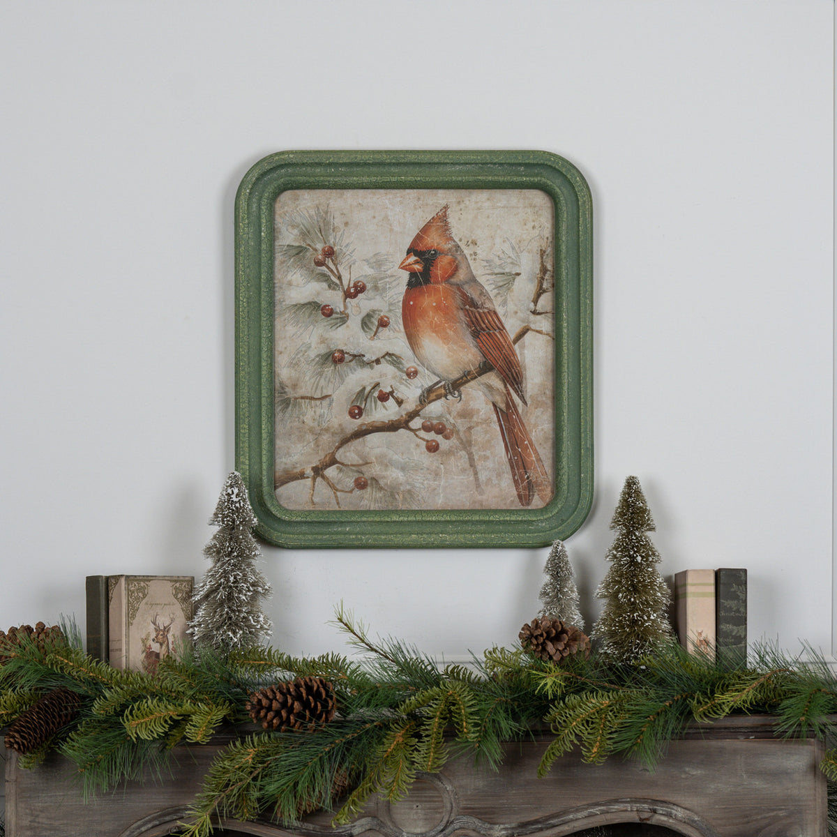 Framed winter scene print on glass showing a red cardinal perched on snow-covered branches against a blue sky.