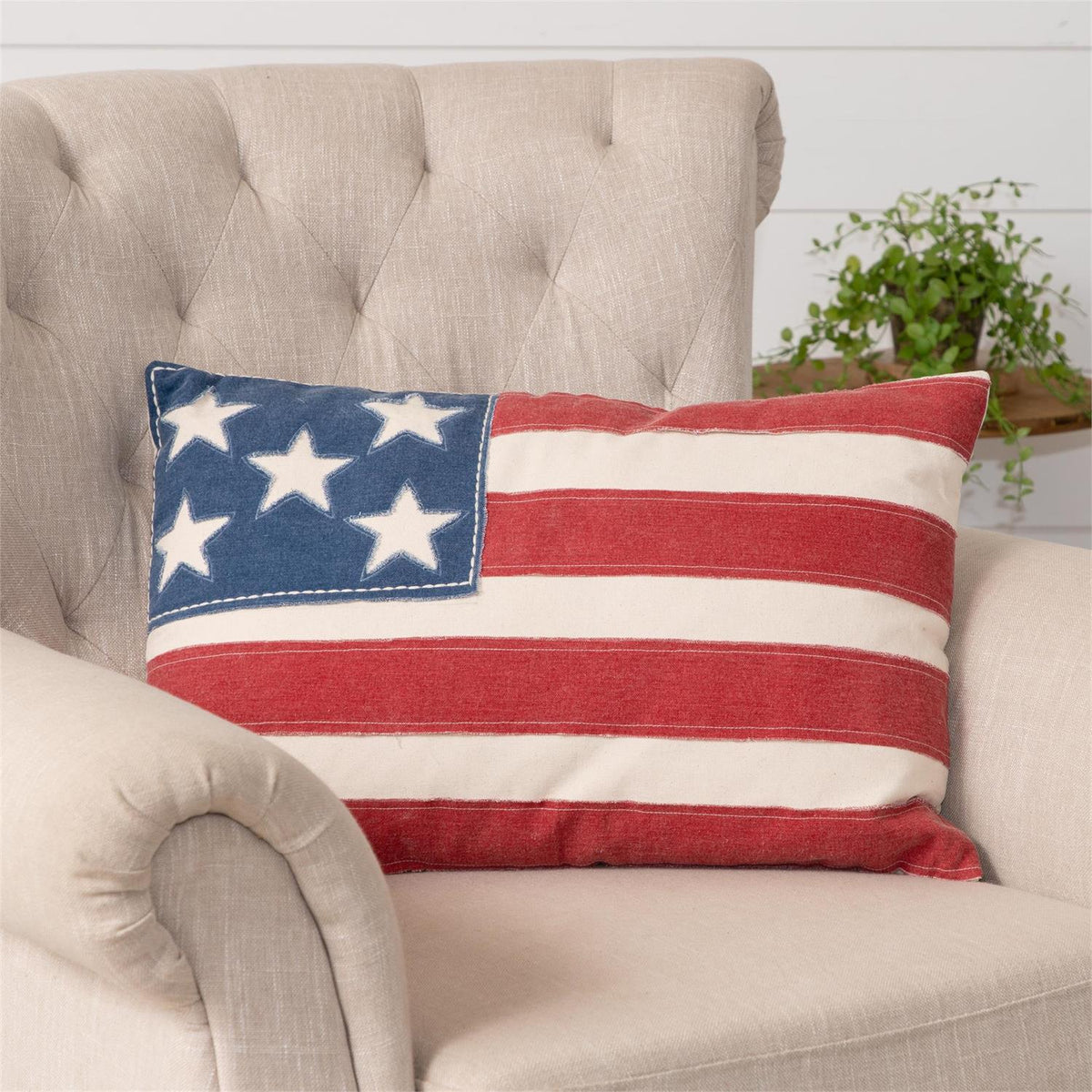 Pillow featuring a patchy American flag pattern with distressed red, white, and blue fabric.