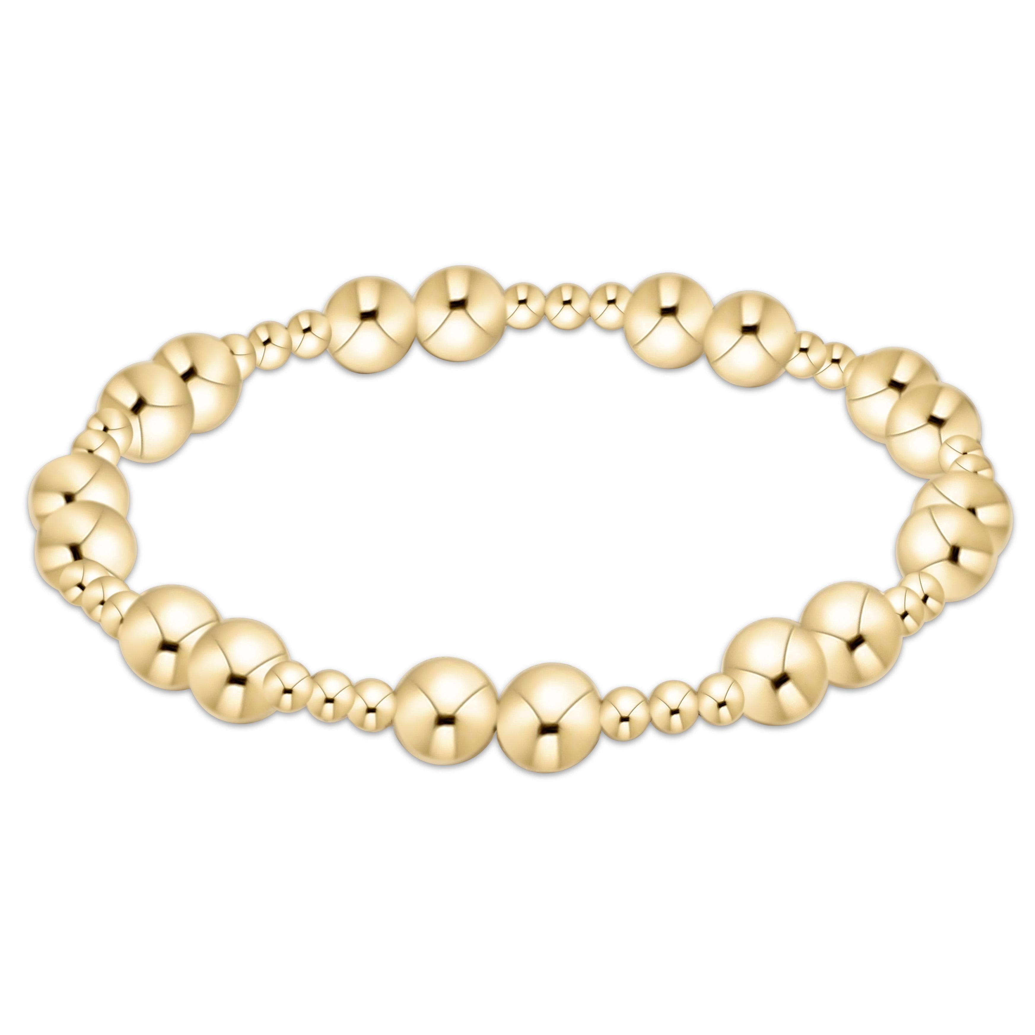 Gold beaded Together Bracelet featuring alternating sizes of polished gold spheres on an elastic band
