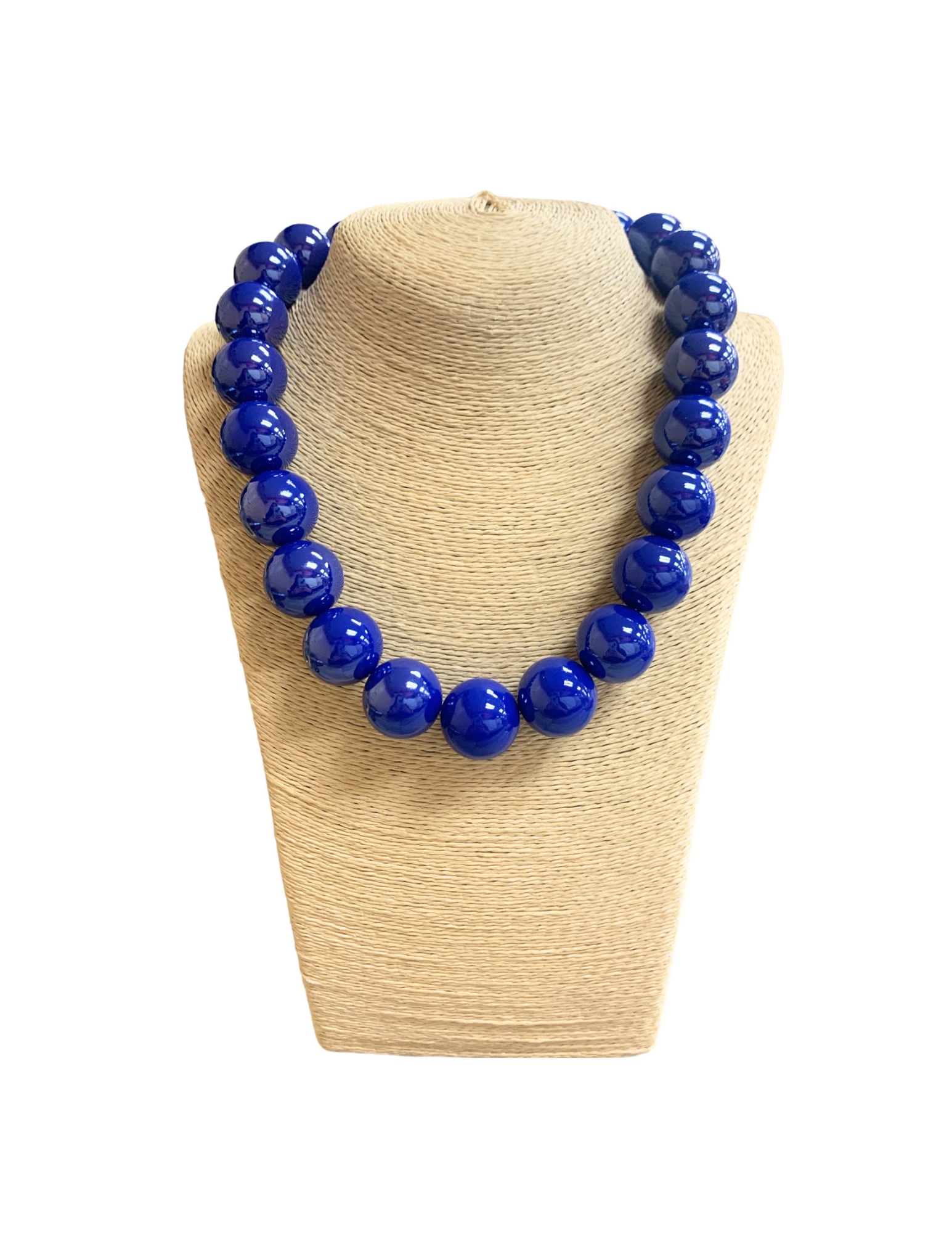 Short necklace with large, glossy blue glass ball beads on a beige textured jewelry bust.