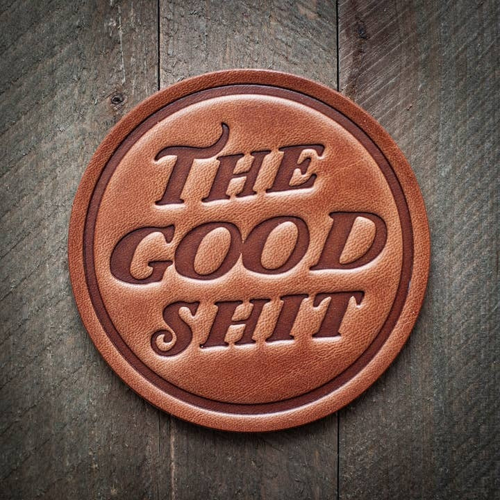Square brown leather coaster with a textured surface.