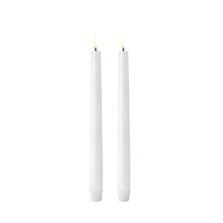 Tall white LED taper candle with smooth finish on a dark background