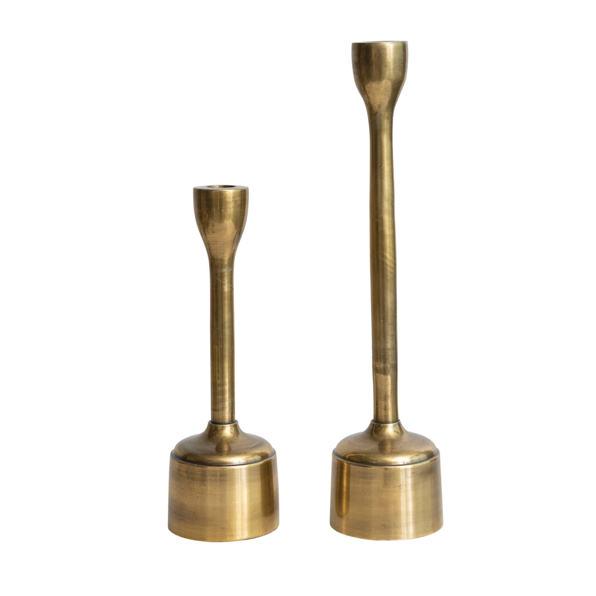 Set of two cast aluminum taper candle holders in an antique brass finish with slim, elegant stems.