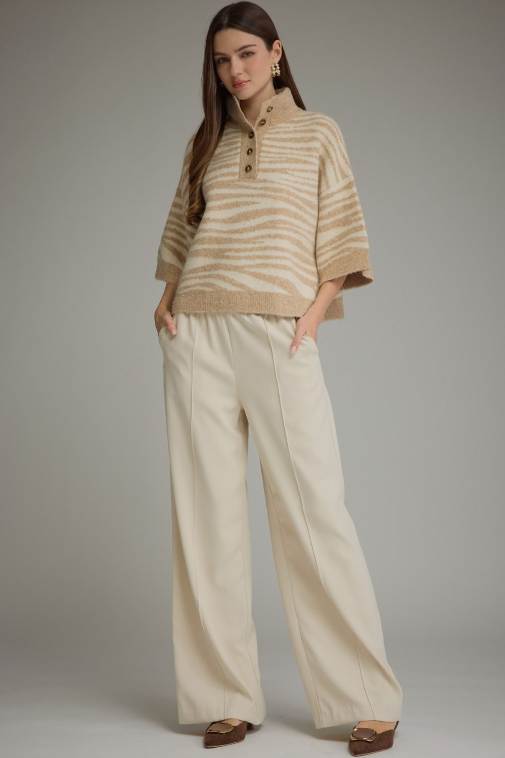 Woman wearing the Chanice abstract animal print 3/4 sleeve knit top with cream wide-leg trousers.