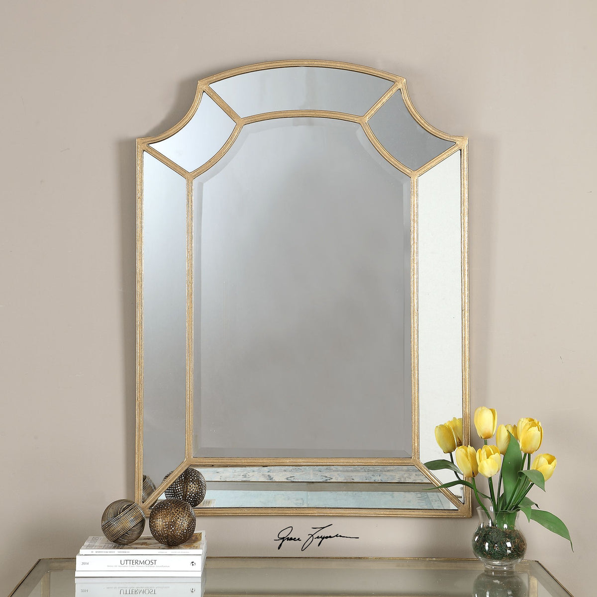Gold arch-shaped wall mirror with a sleek metallic frame.