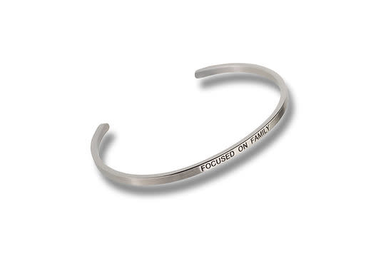Silver-toned metal cuff bracelet engraved with the words FOCUSED ON FAMILY.