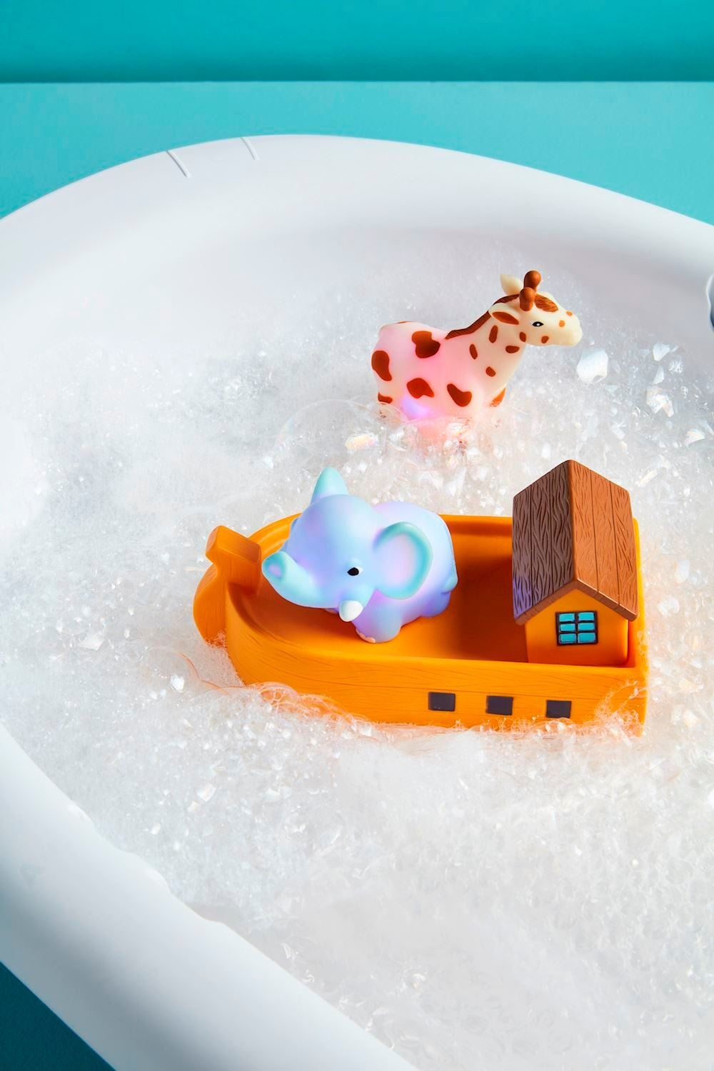Three rubber Noah's Ark bath toys with water-activated lights in red, blue, and yellow.