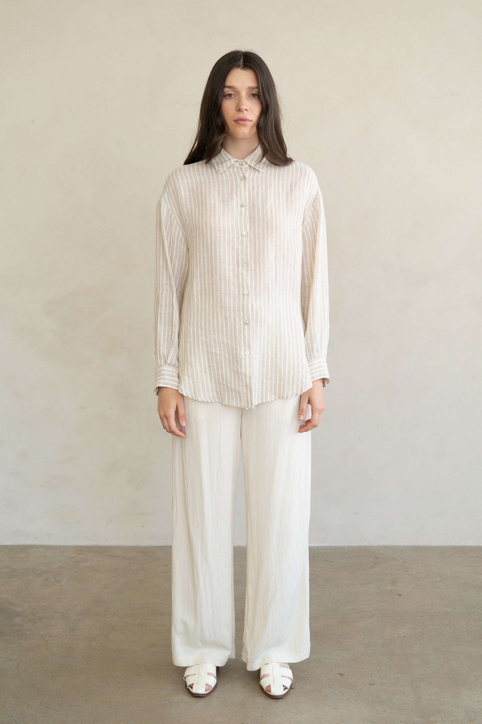 Woman wearing the Eliana Striped Linen Essential Shirt in a relaxed fit with white wide-leg pants.