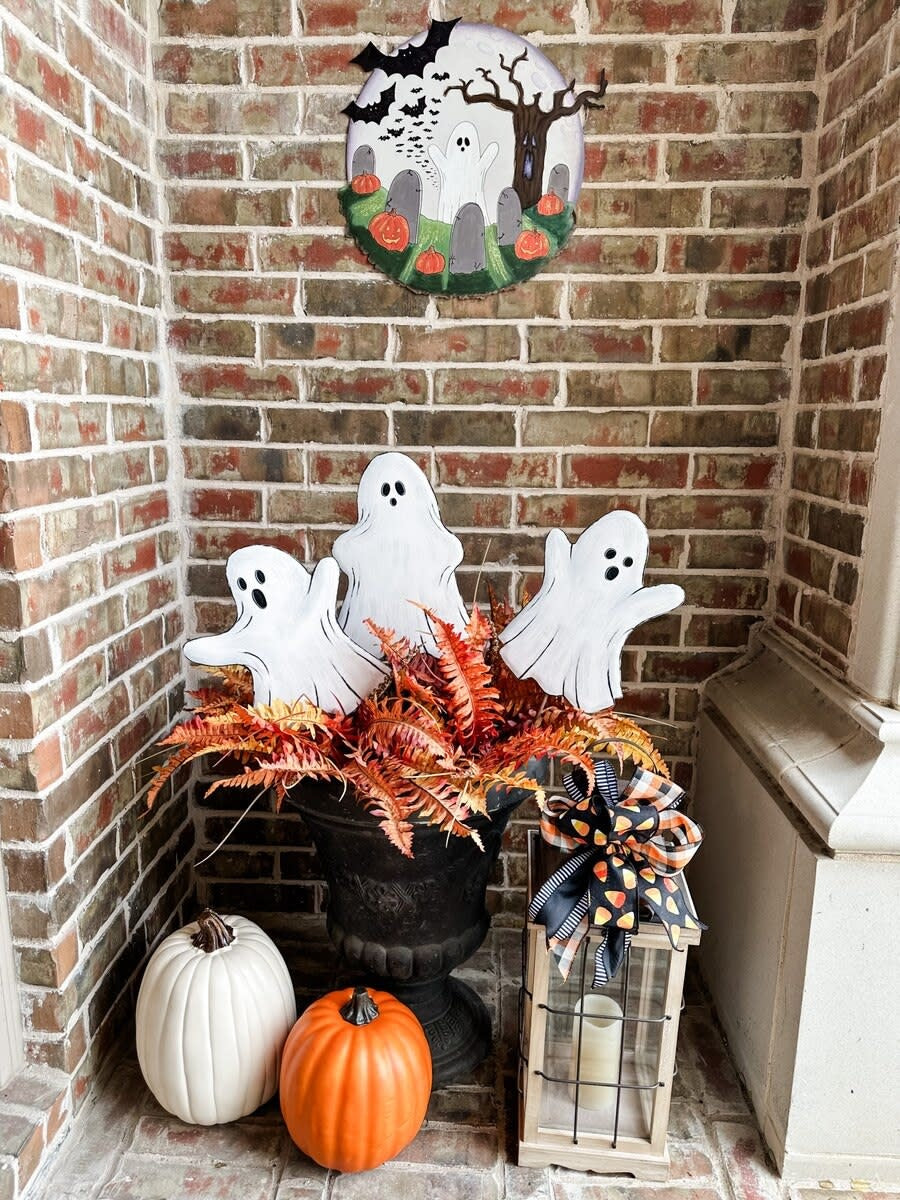 White ghost-shaped Halloween stake with black outline detailing.
