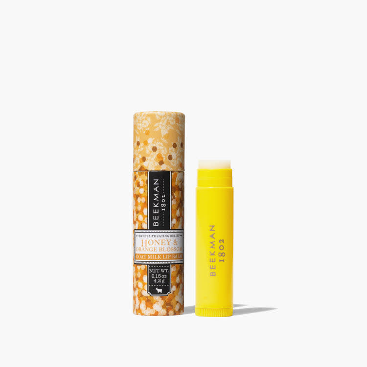 Beekman Lip Balm in honey-orange blossom housed in a clear tube with gingham-patterned paper packaging.