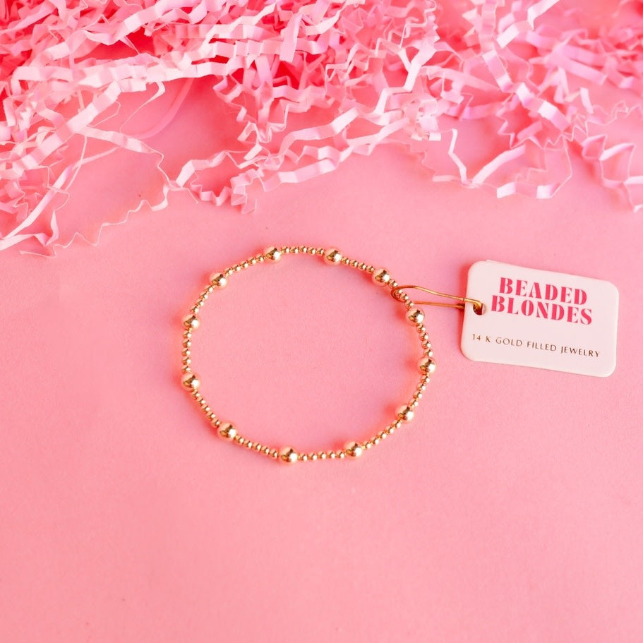 Gold-filled beaded bracelet on durable elastic string with a lively pattern.