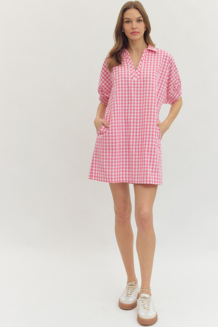Woman wearing a pink and white Naomi Gingham Short Sleeve Mini Dress with side pockets and sneakers.