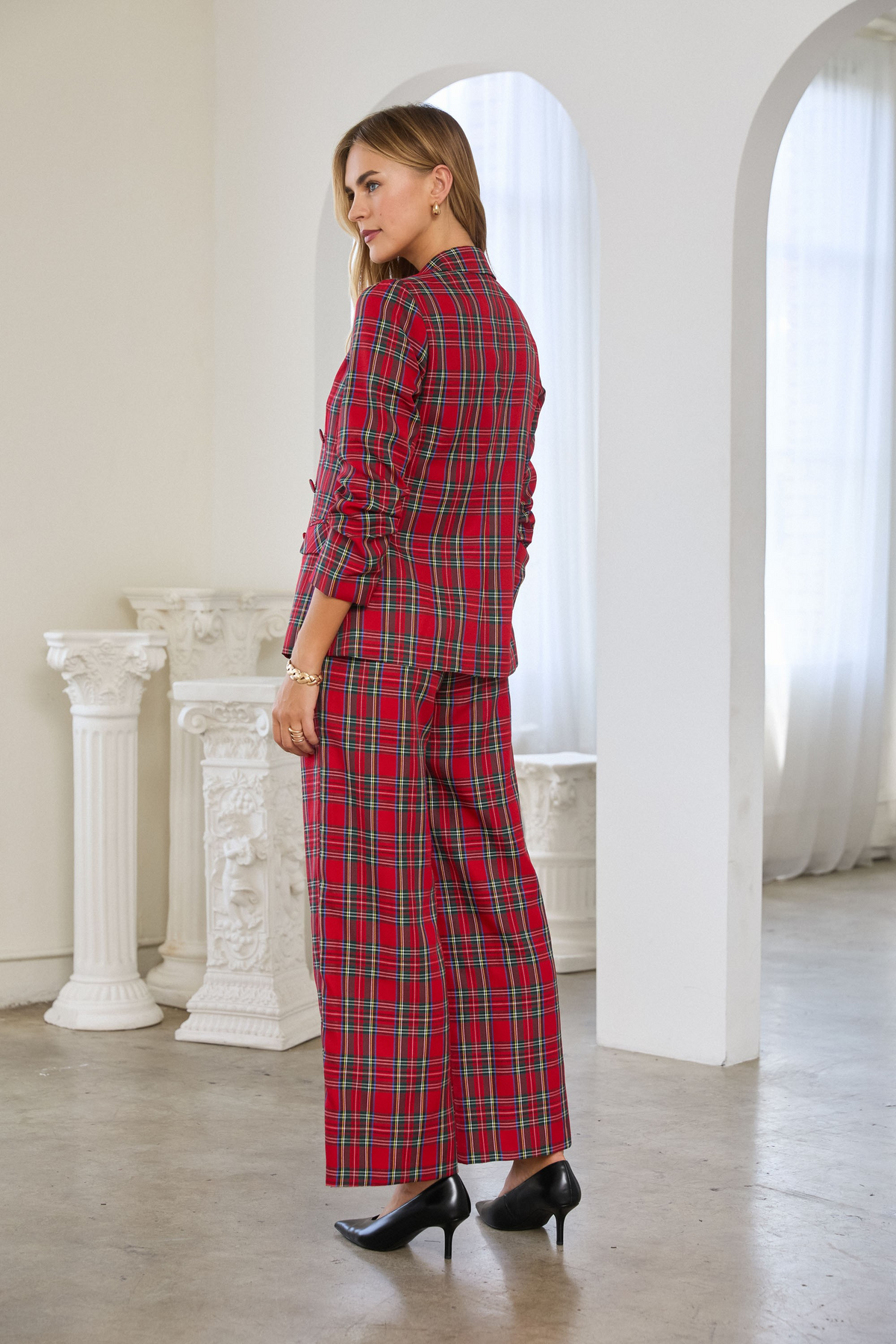 Woman wearing a red Hera Tartan Check Double-Breasted Blazer and matching wide-leg plaid trousers.